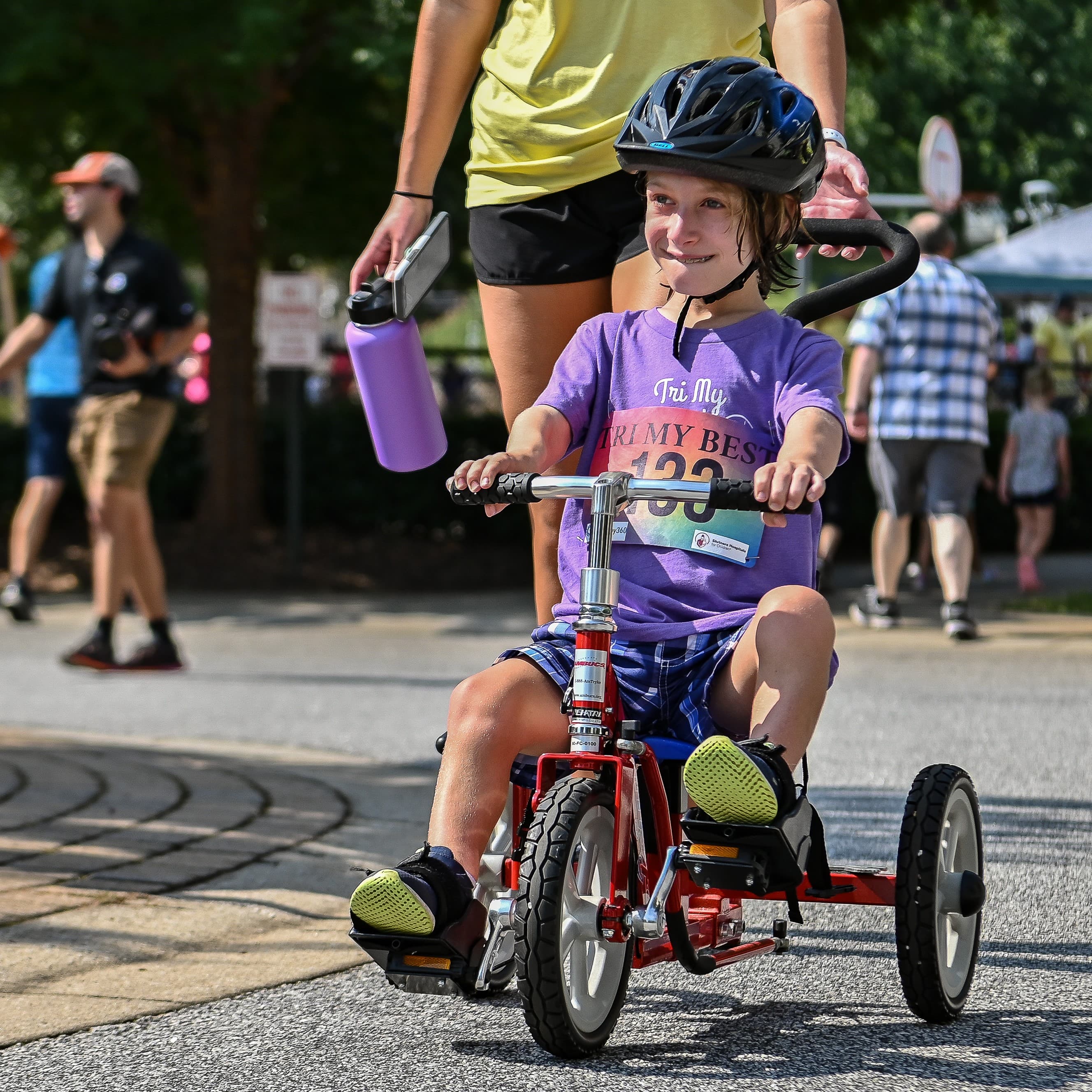 Cohen rides a red tricycle in adaptive triathalon