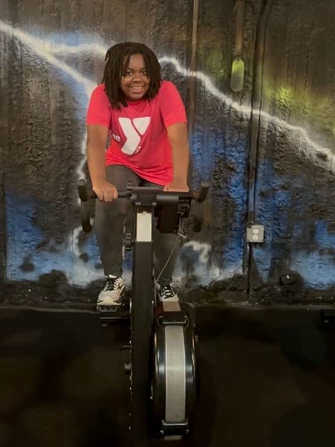 athlete rides stationary bike during workout at the Junkyard