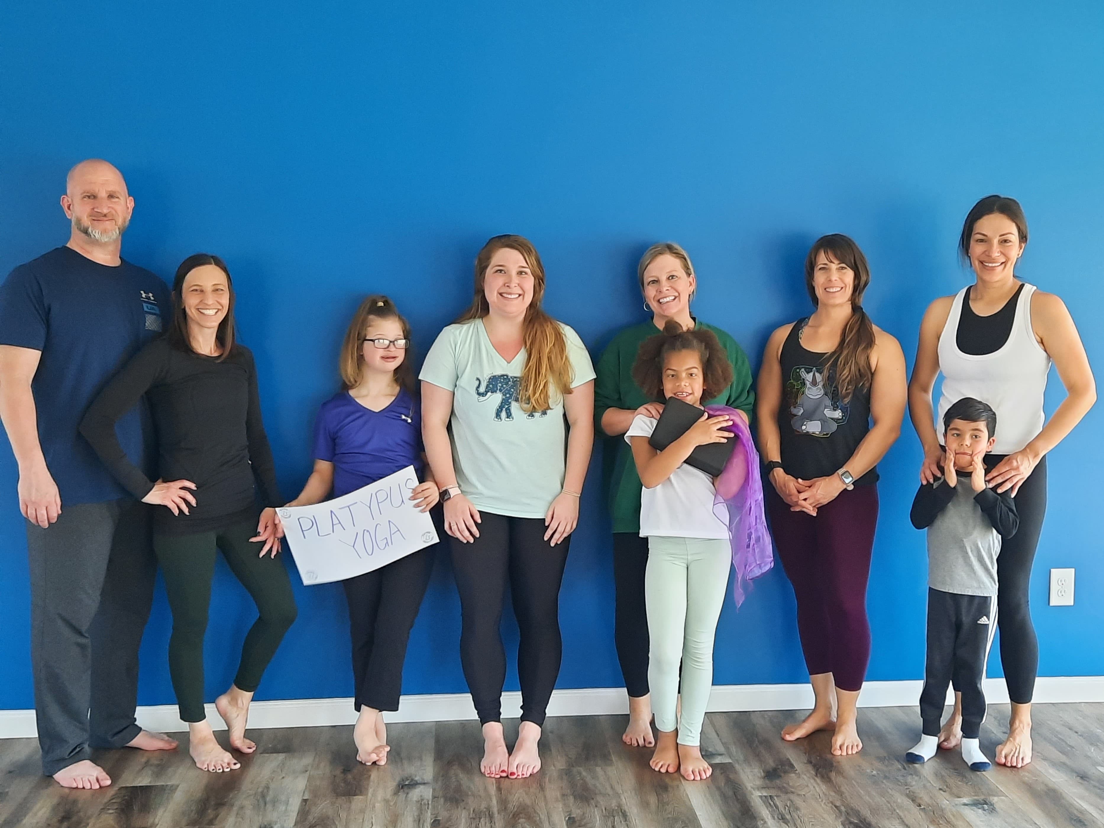 yoga particpants stand smiling at the camera after class