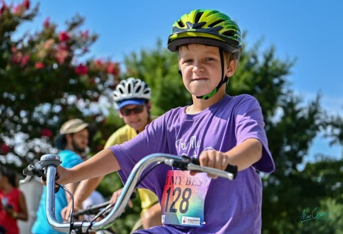 Tri My Best biker with green helmet looks determinedly at camera