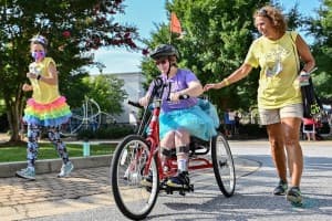 tri my best biker in tutu bikes as buddies jog alongside