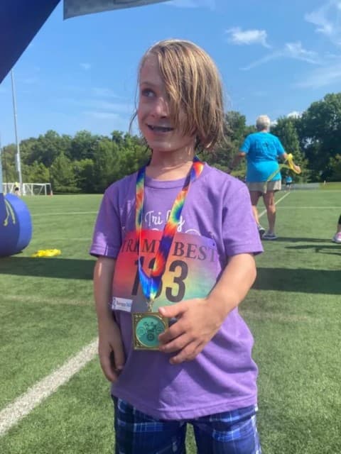 tri my best participant Cohen poses with medal