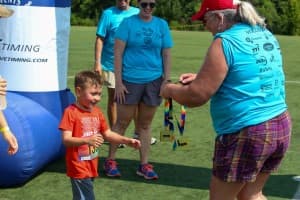 tri my best participant receives medal from volunteer