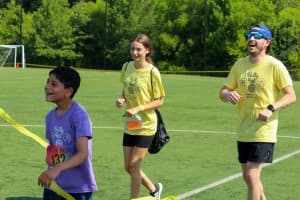 tri my best runner crosses finishline with buddies behind