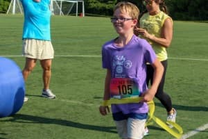 tri my best runner proudly crosses finishline