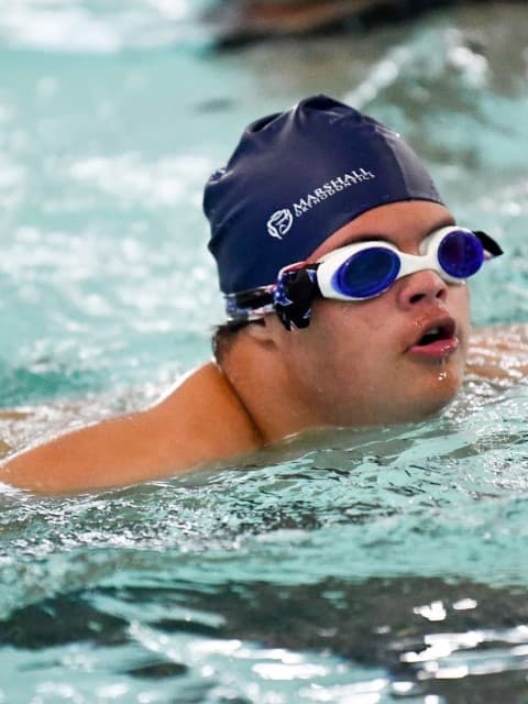 tri my best swimmer swims wearing blue swimcap and goggles
