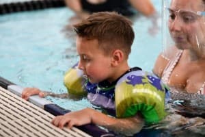 tri my best swimmer holds onto pool wall